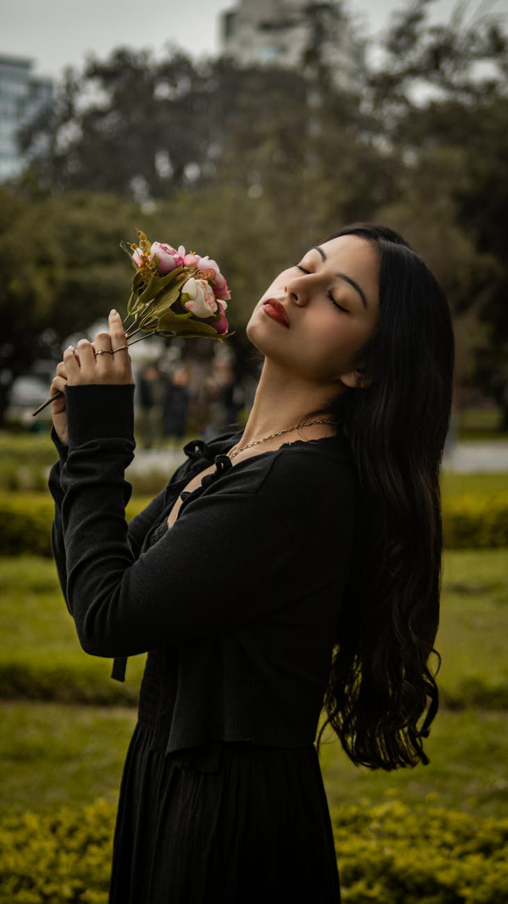 woman in black clothing posing with flowers