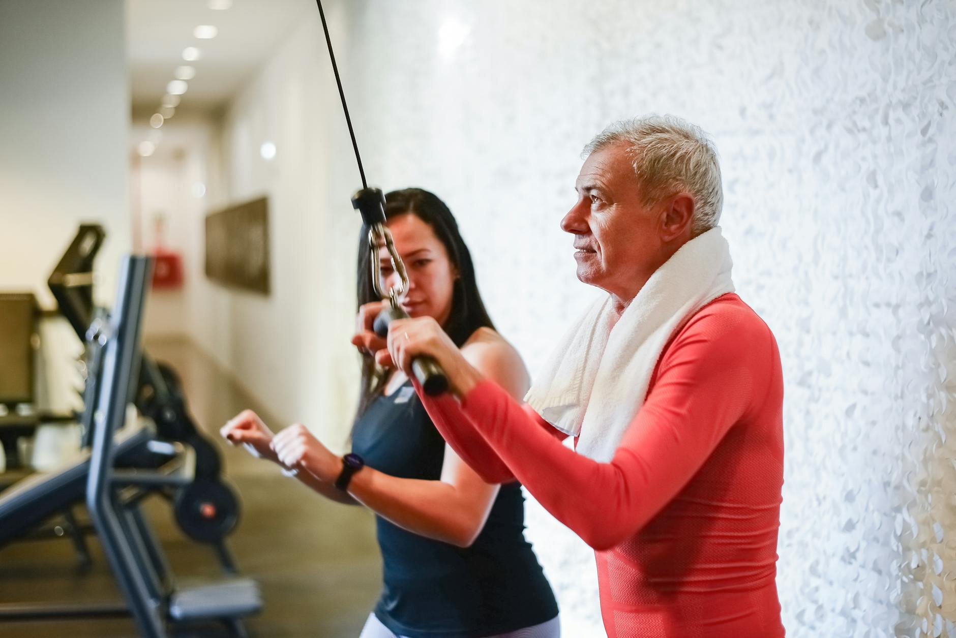 a man pulling an equipment while listening to his trainer standing beside him